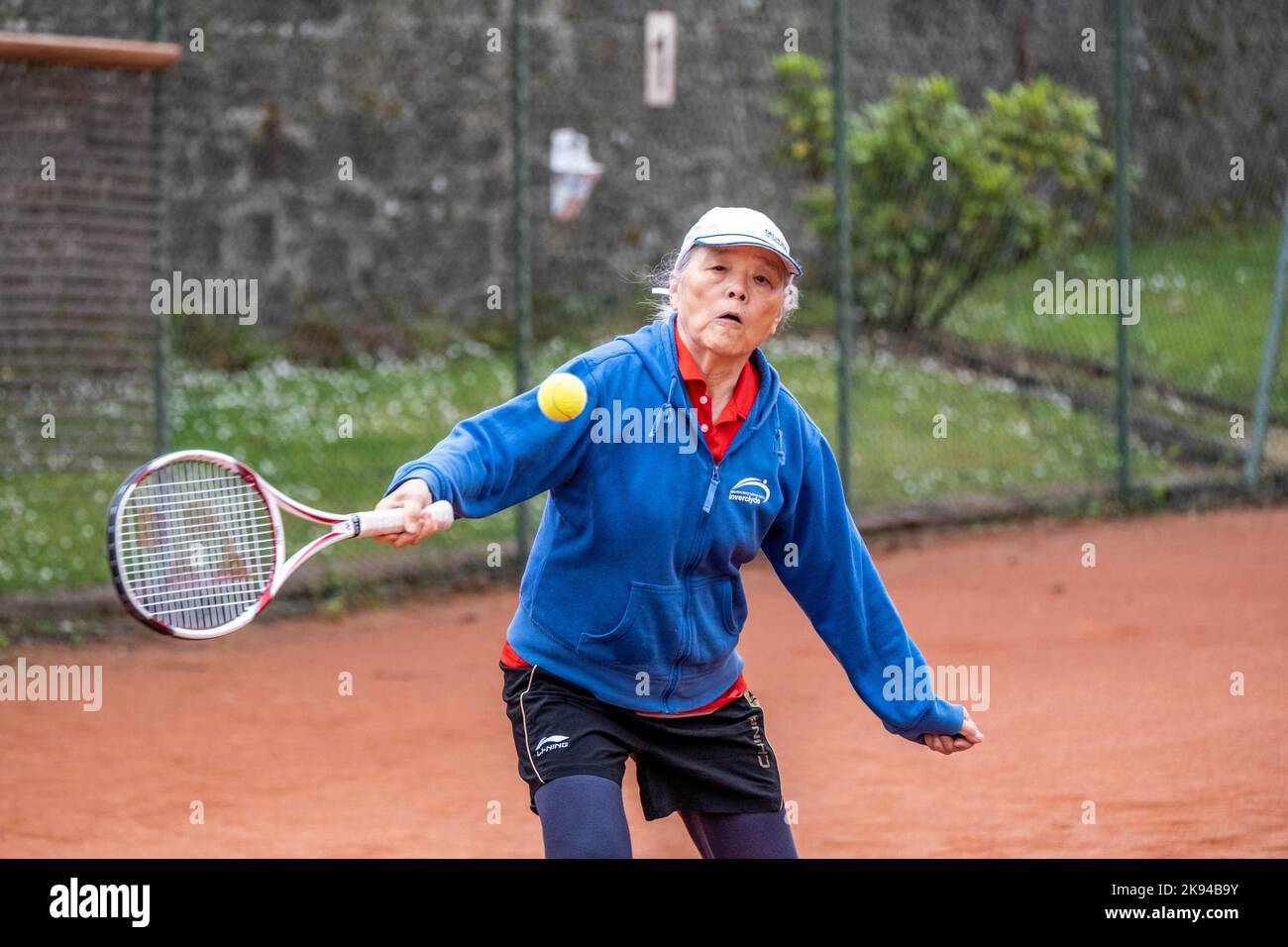 Persone di mezza età e anziane che imparano a giocare a tennis Foto Stock