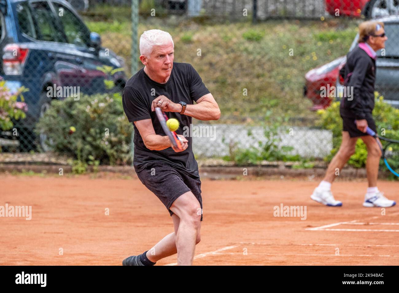 Persone di mezza età e anziane che imparano a giocare a tennis Foto Stock