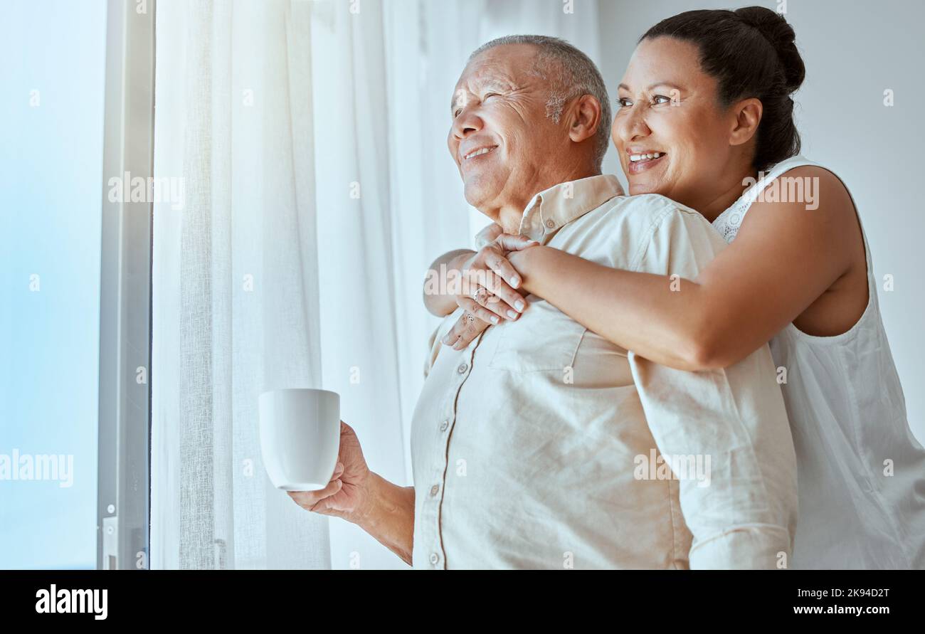 Coppia anziana, futuro di pensione e visione della finestra per pensare, amore e cura in Colombia casa. Felice, anziana e pensante donna abbraccia l'uomo in casa di Foto Stock
