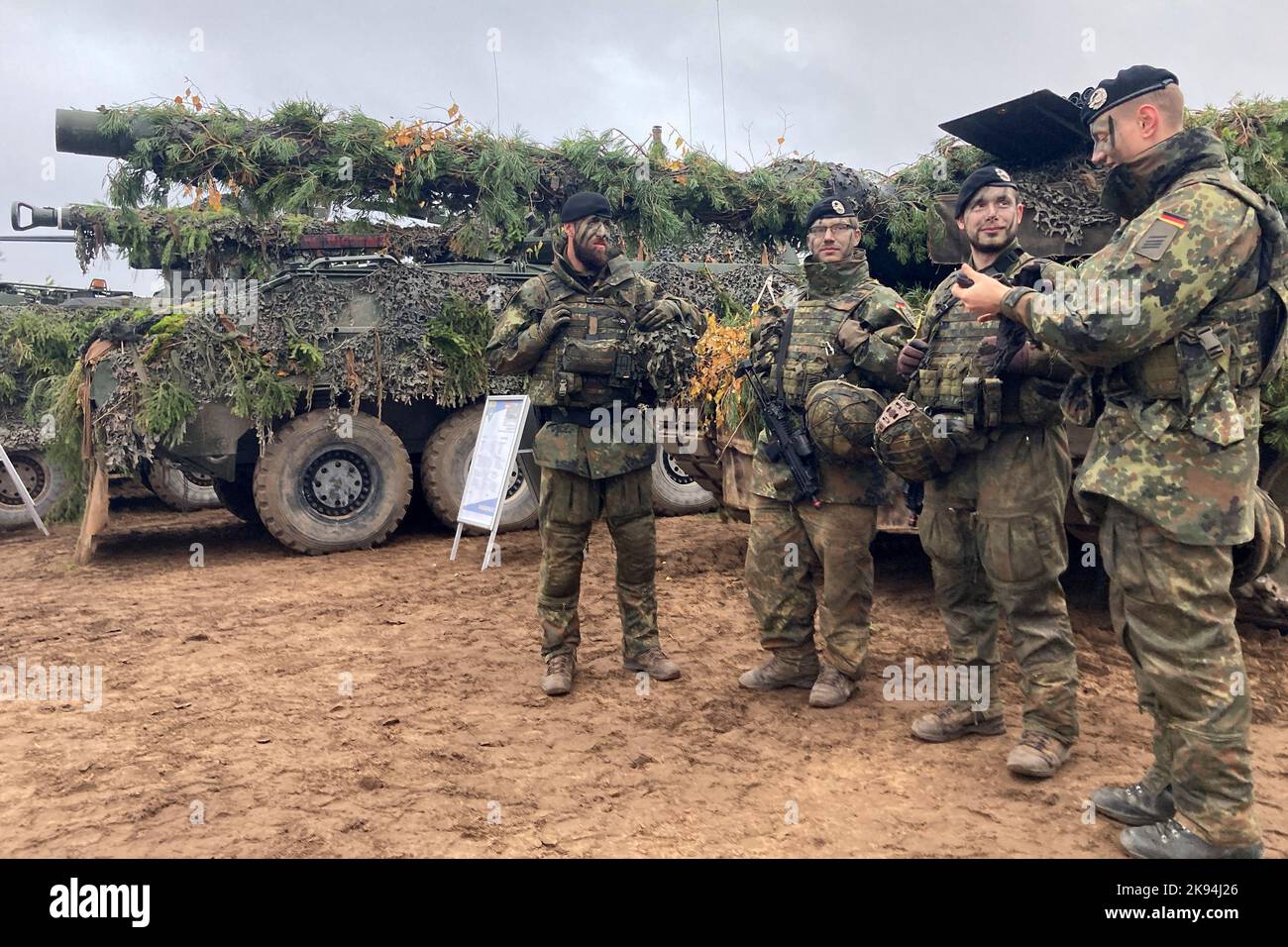 Pabrade, Lituania. 26th Ott 2022. Soldati tedeschi si trovano di fronte a un carro armato leopardo durante un esercizio militare "Lupo di ferro II" presso l'area di addestramento militare di Pabrade. Circa 3.500 soldati provenienti da dieci paesi della NATO e 700 veicoli militari partecipano all'esercizio, che si svolge due volte all'anno e dura quasi due settimane. Oltre alle truppe lituane, partecipa anche il gruppo di battaglia della NATO guidato dalla Bundeswehr nel paese dell'Unione europea. Credit: Alexander Welscher/dpa/Alamy Live News Foto Stock