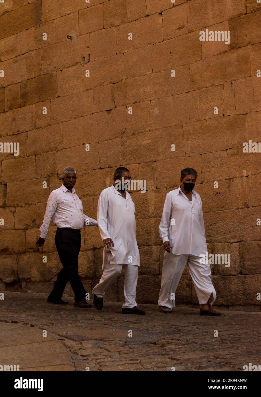 Uno scatto verticale di tre uomini di mezza età che camminano lungo un ripido pendio del Forte dorato Foto Stock