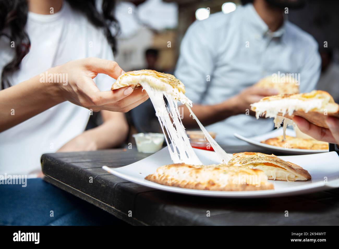 Formaggio di naan ripieno tirare la mano ragazza mangiare all'aperto nella strada del cibo karachi. Foto Stock