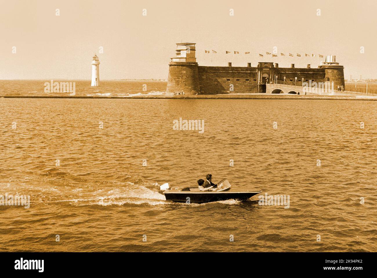Vintage New Brighton, 1970. Perch Rock o la batteria. Wallasey, turisti che si godono un giro in barca, Merseyside. Immagine seppia, Foto Stock
