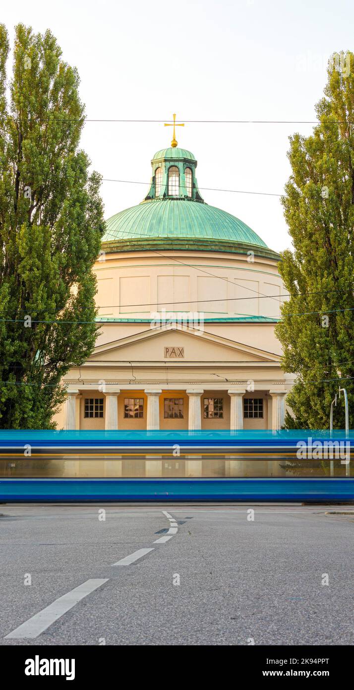 Uno scatto verticale del cimitero di Ostfriedhof con l'autobus in un movimento sfocato di fronte Foto Stock