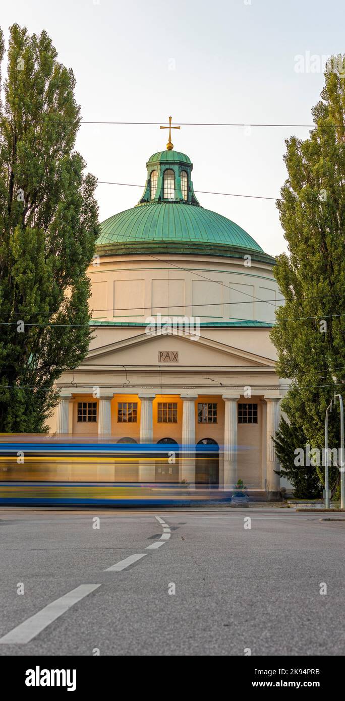 Uno scatto verticale del cimitero di Ostfriedhof con l'autobus in un movimento sfocato di fronte Foto Stock