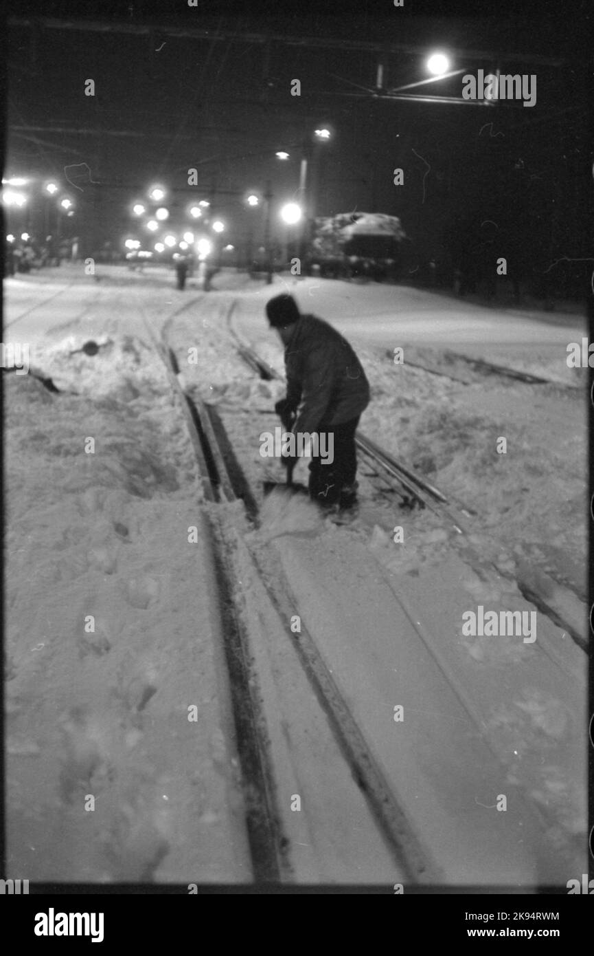 Rimozione della neve dell'ingranaggio con la pala e pulizia dello spazio tra le guide e le alette dell'ingranaggio. Foto Stock