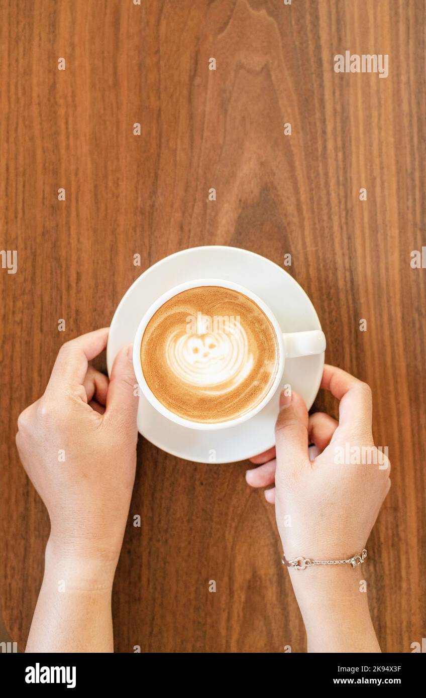 Arte del latte di zucca di Halloween con mano sul tavolo di legno Foto Stock