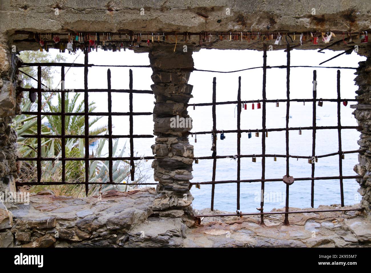 Finestra barrata che si affaccia sul mare con le stesse serrature d'amore Foto Stock