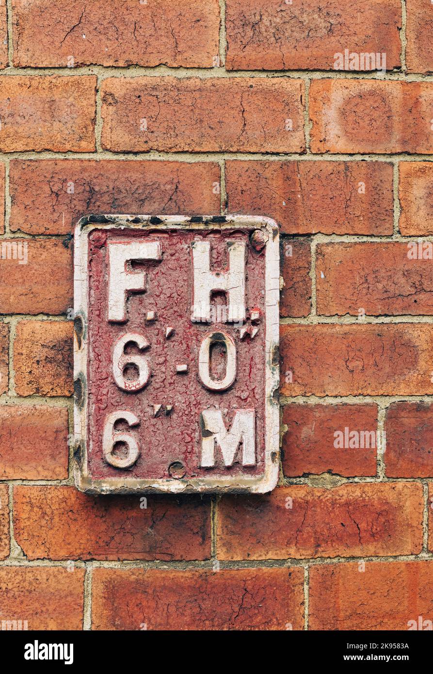 Old Iron Fire Hydrant FH segno sul muro di mattoni Leeds Yorkshire UK Foto Stock