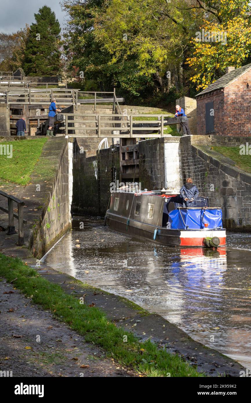 Una chiatta (barca a remi, barca a fondo piatto) entra nel blocco inferiore delle cinque chiuse di Rise a Bingley, Yorkshire sul canale Liverpool di Leeds. Foto Stock