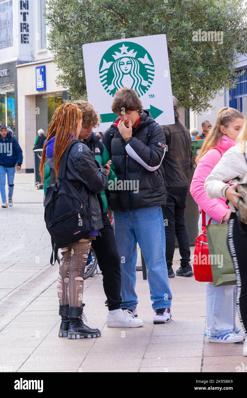 Irlanda Eire Dublin Grafton Street Street scene adolescenti Goth girl strappato collant stivali Dreadlocks cartello Starbucks che chiacchiera con gli amici del tempo libero Foto Stock