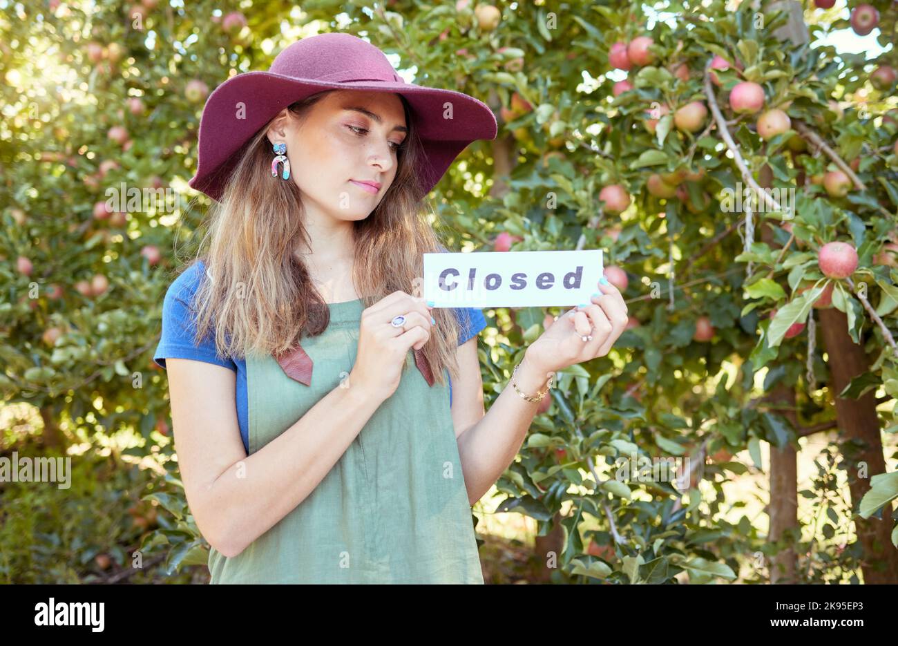 Donna contadina, segno chiuso e mela fattoria, agricoltore e sostenibilità aziendale. Dipendente agricolo con icona o bordo per la pubblicità fine di Foto Stock