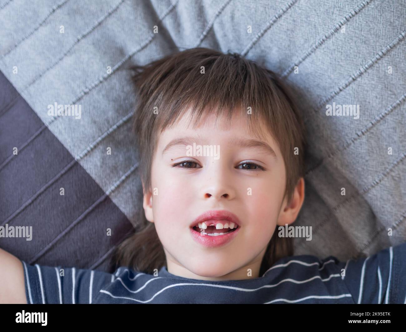 Il ragazzo sorridente mostra un buco in fila di denti in bocca. Un incisor è caduto fuori appena ora. Primo piano foto gengive per dentista. Foto Stock