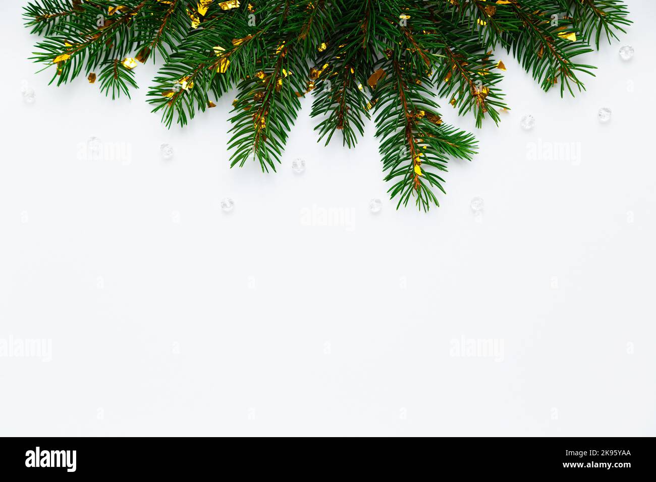 Layout Natale, Capodanno con spazio per testo. Rami di abete naturale con coriandoli dorati su fondo bianco piatto. Bordo dell'albero di Natale Foto Stock
