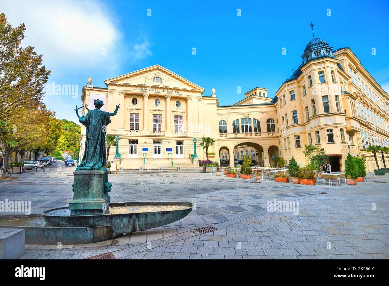 Vista dell'edificio del teatro e della scultura d'arte con una piccola fontana sulla piazza della città di Baden, vicino a Vienna. Austria Foto Stock
