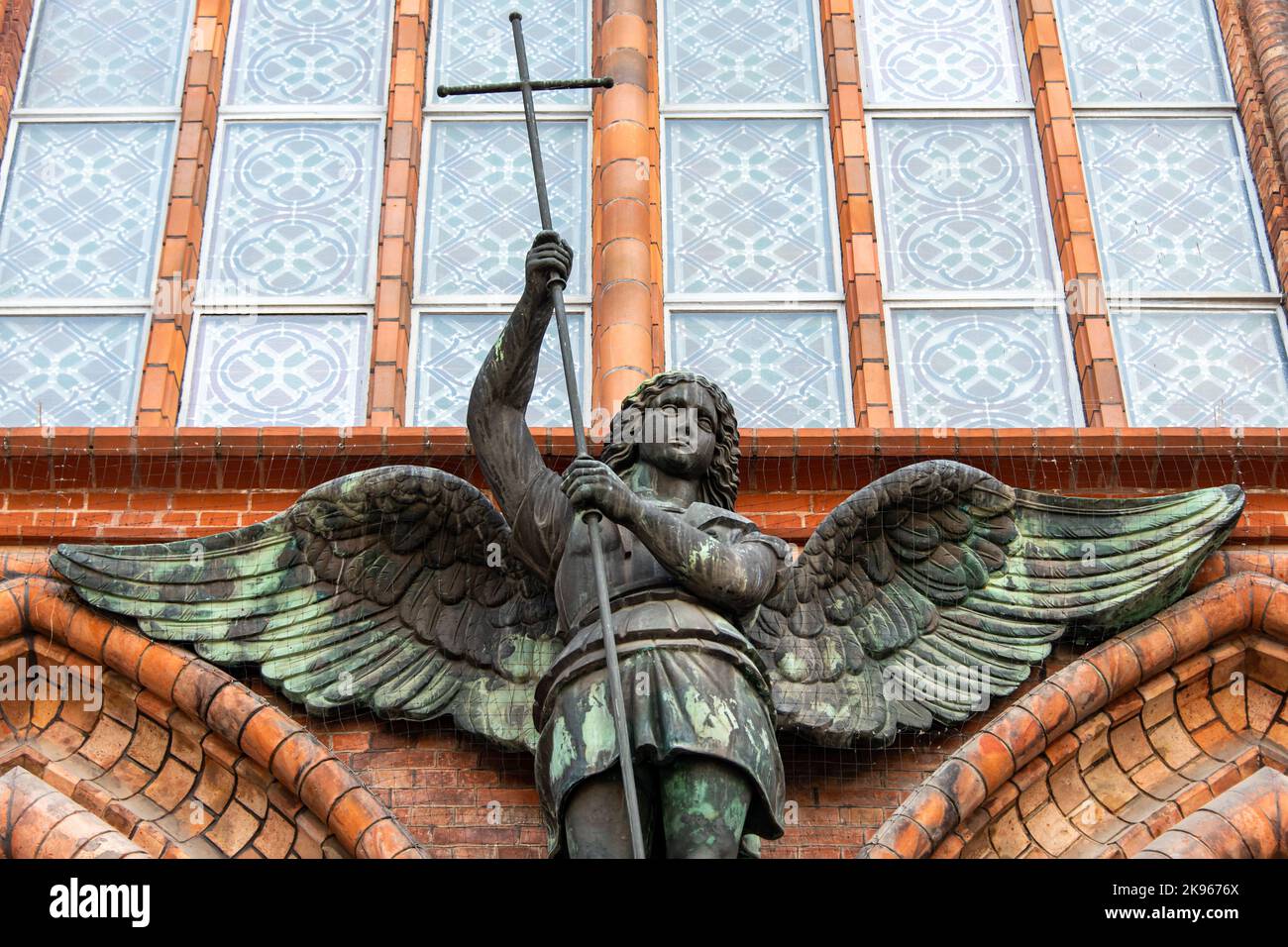 Statua dell'Arcangelo Michele uccidendo il serpente, dettagli esterni della chiesa cristiana. Tempio cattolico a Berlino, Germania, architettura gotica. Foto Stock