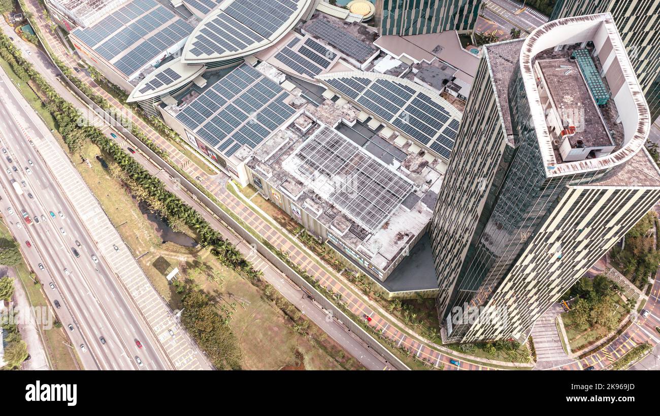 Malesia - 13 ottobre 2022: Vista aerea direttamente sopra un'autostrada. Vista dall'alto della strada asfaltata passa il centro commerciale con pannello solare sul tetto. Antenna p Foto Stock