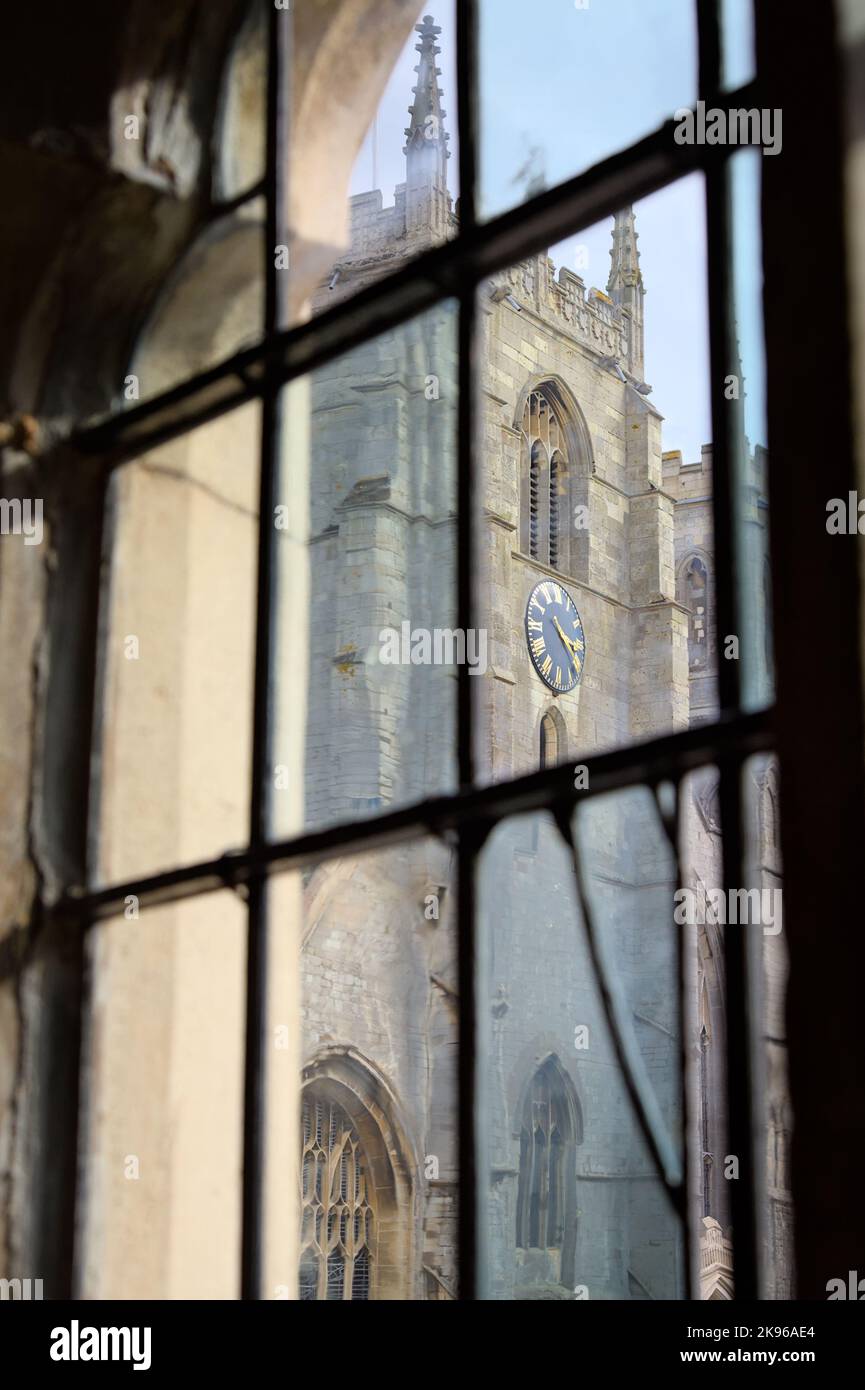 Vista della Torre dell'Orologio di King's Lynn Minster, la Chiesa del Priorato di Saint Margaret attraverso un'antica finestra multi-lite del Municipio, Regno Unito Foto Stock