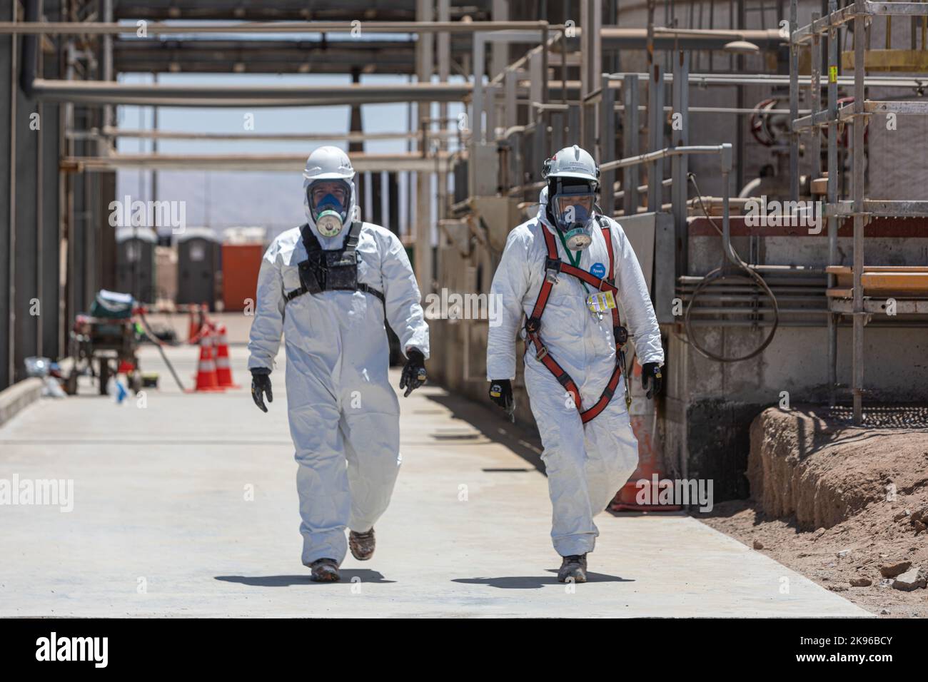 Antofagasta, Cile. 25th Ott 2022. I lavoratori camminano in tute protettive e maschere attraverso lo stabilimento di produzione di carbonato di litio della società cilena MQ. Questa raffineria tratta il litio estratto dai laghi salati nel deserto di Atacama. Credit: Lucas Aguayo Araos/dpa/Alamy Live News Foto Stock