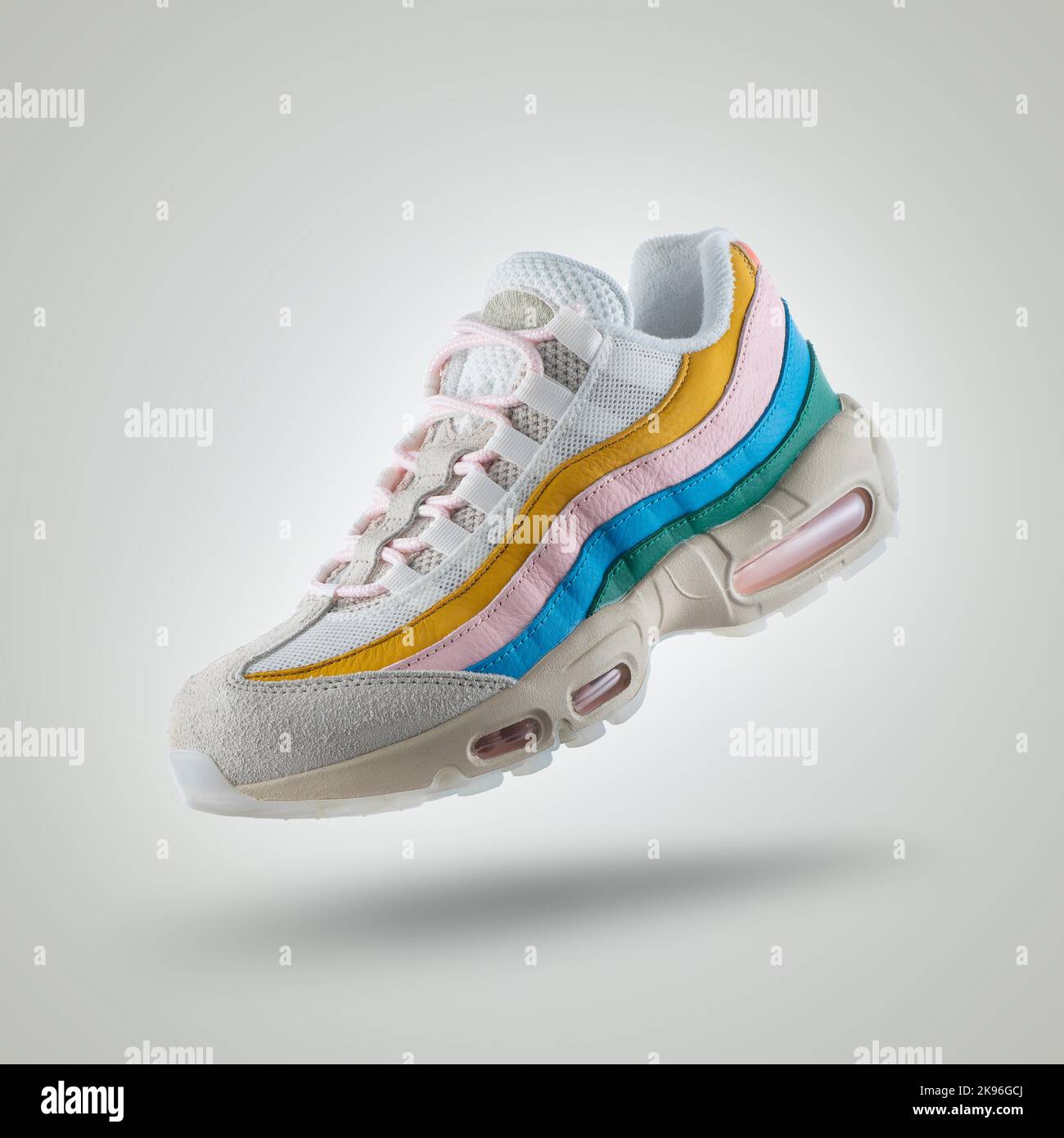 Sneaker bianca con una varietà di colori, scarpa su sfondo bianco sfumato, giallo, rosa, blu, verde Foto Stock