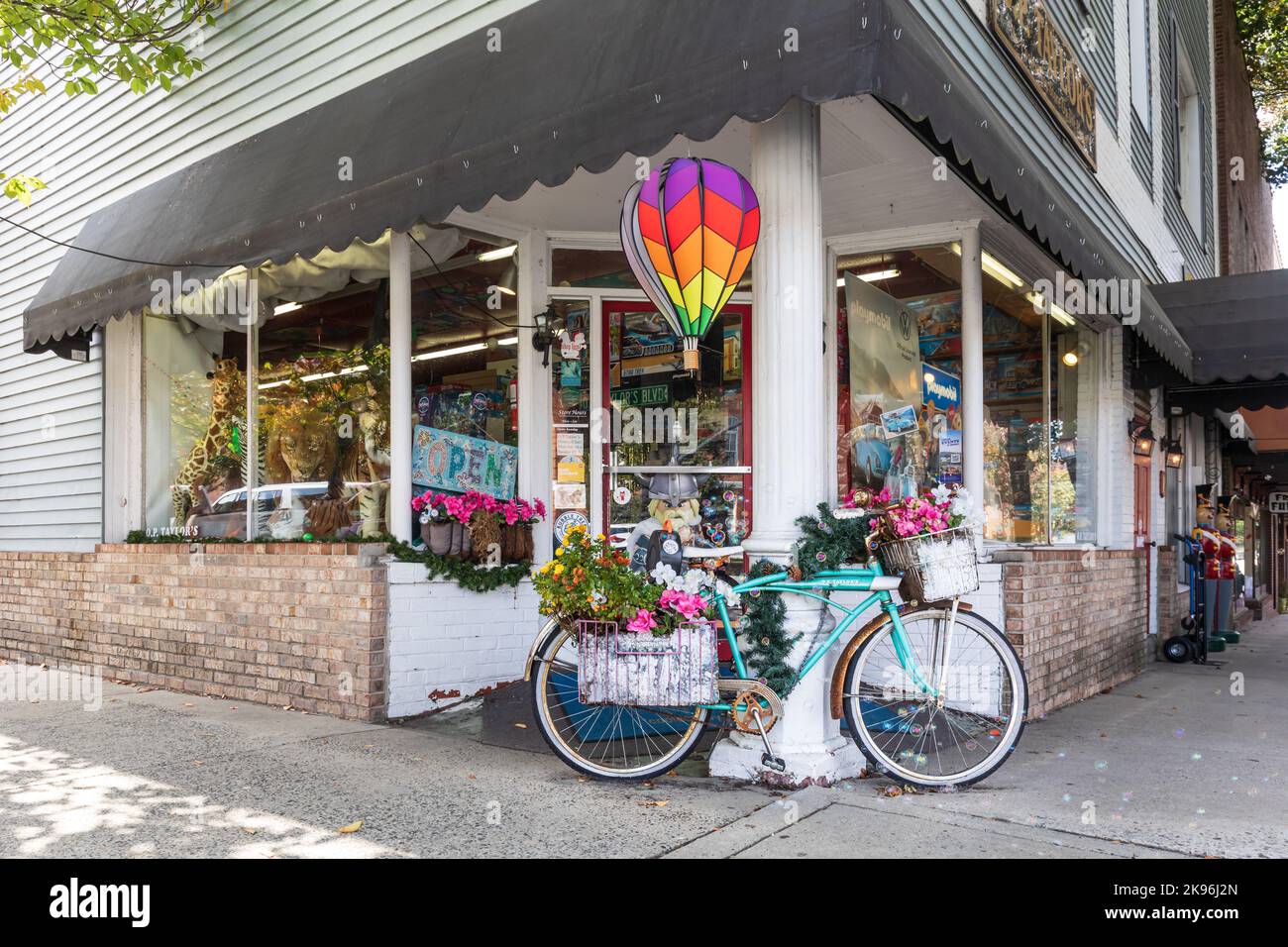 BREVARD, NORTH CAROLINA, USA-9 OTTOBRE 2022: Negozio di giocattoli di O. P. Taylor, che mostra l'ingresso all'angolo esterno con una bicicletta coperta da fiori in esposizione. Foto Stock