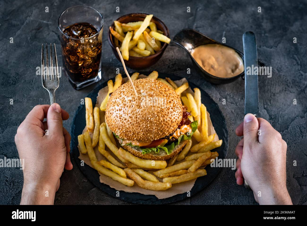 Mani maschili sopra l'hamburger Foto Stock
