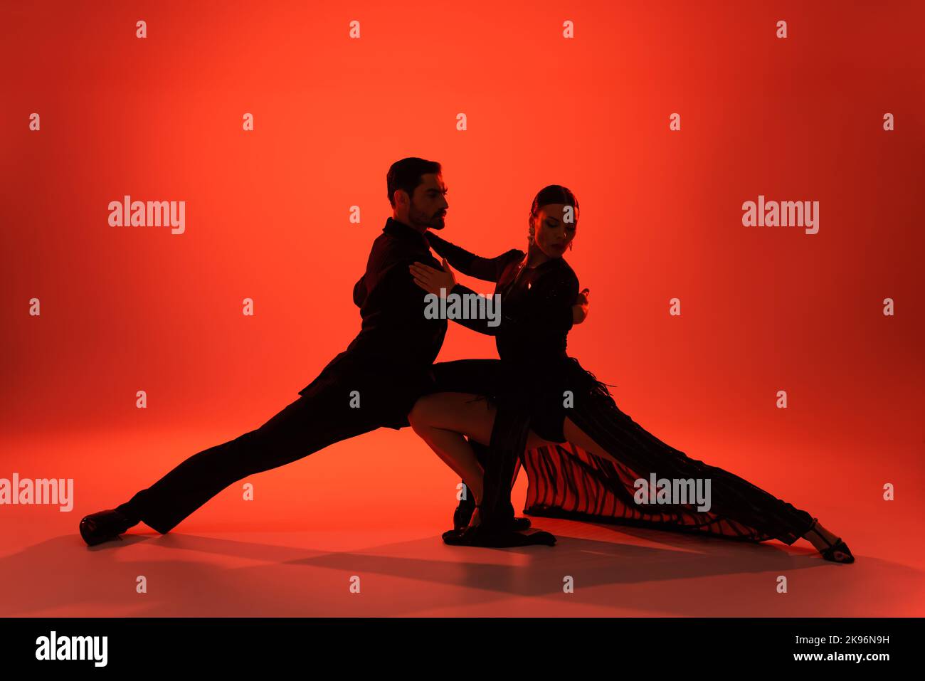Silhouette di elegante coppia di tango da ballo su sfondo rosso Foto Stock
