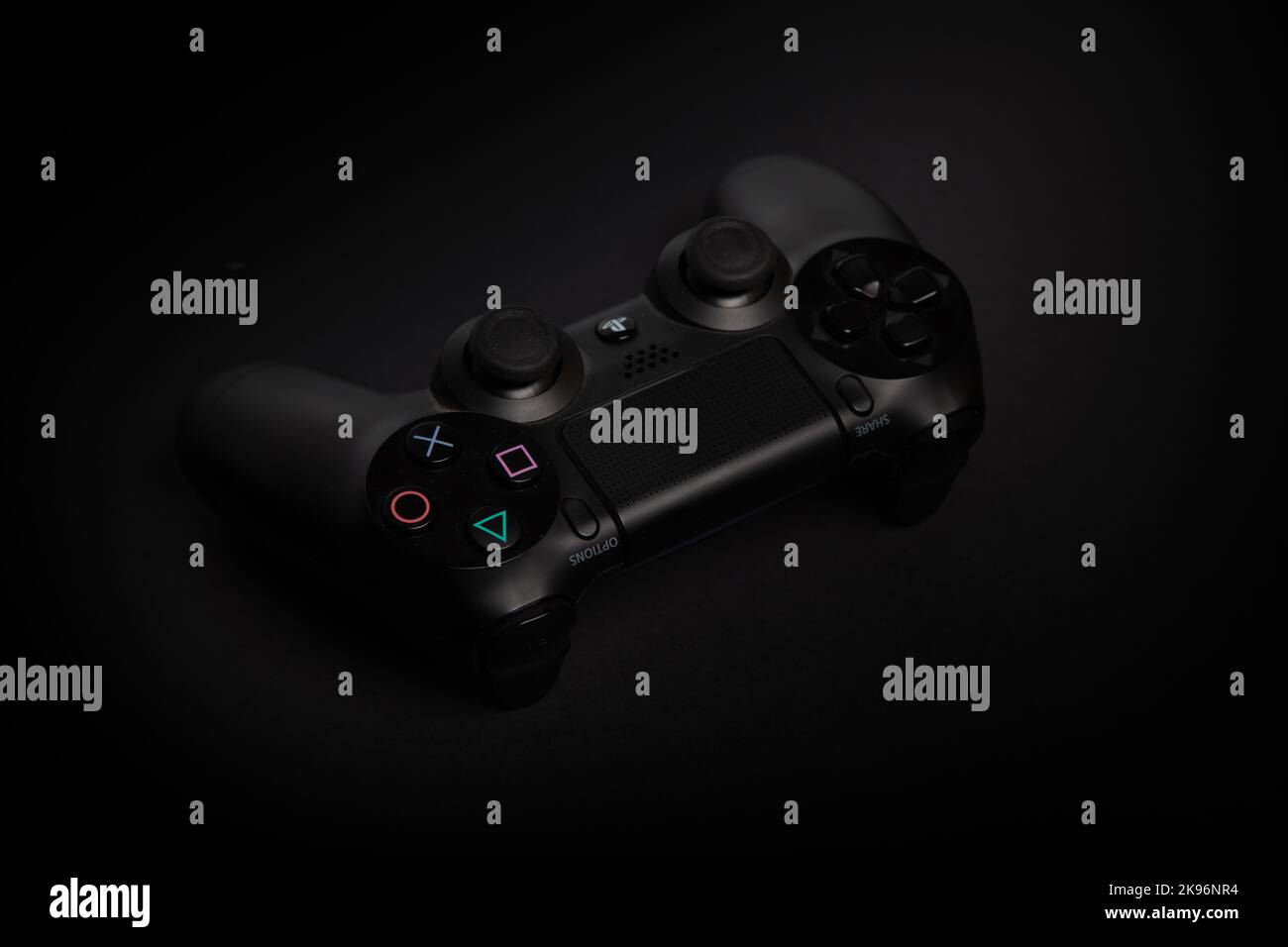 un dettaglio di un joypad di gioco playstation su sfondo nero e scuro, uno scatto professionale da studio Foto Stock