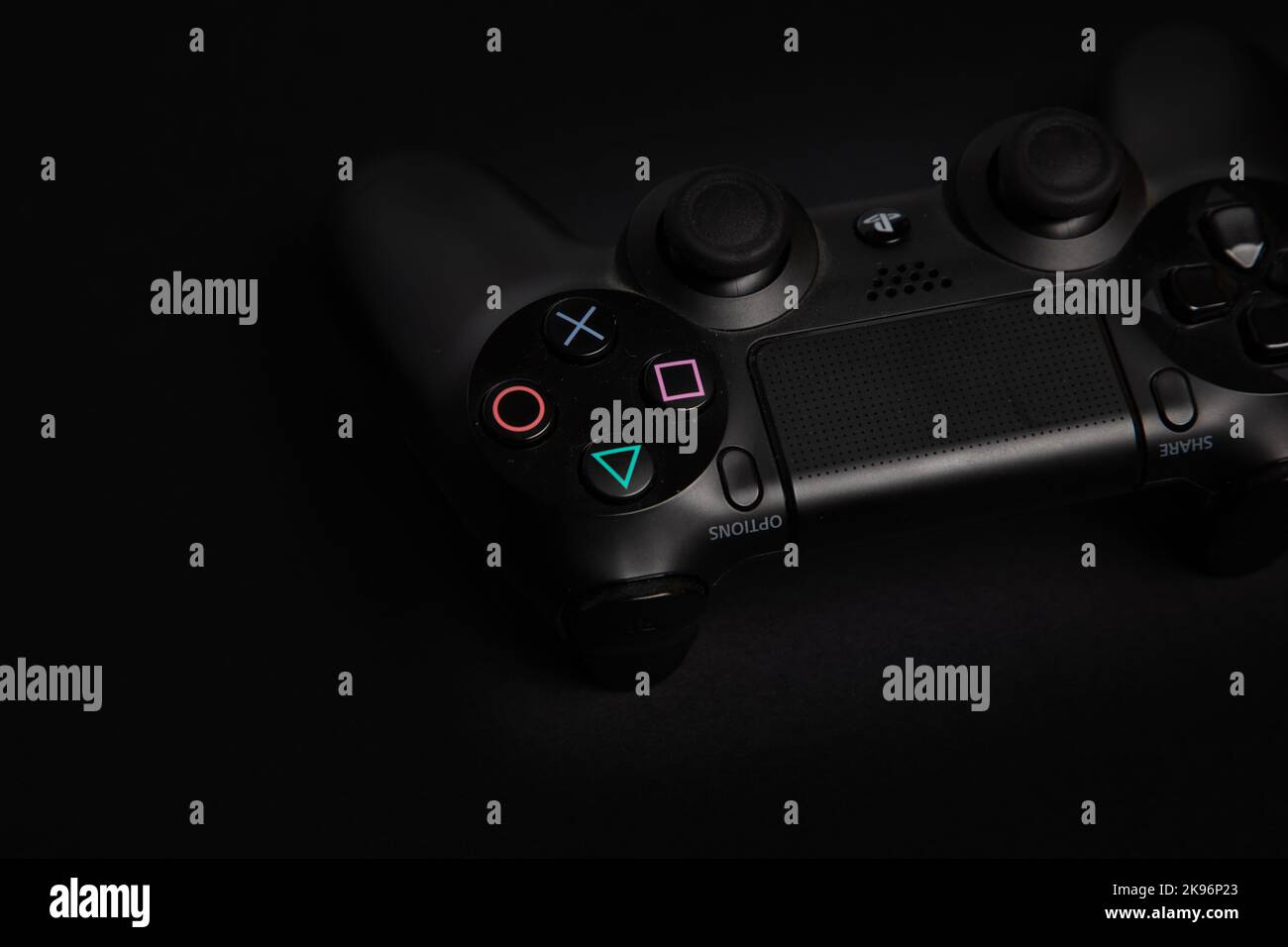 un dettaglio di un joypad di gioco playstation su sfondo nero e scuro, uno scatto professionale da studio Foto Stock
