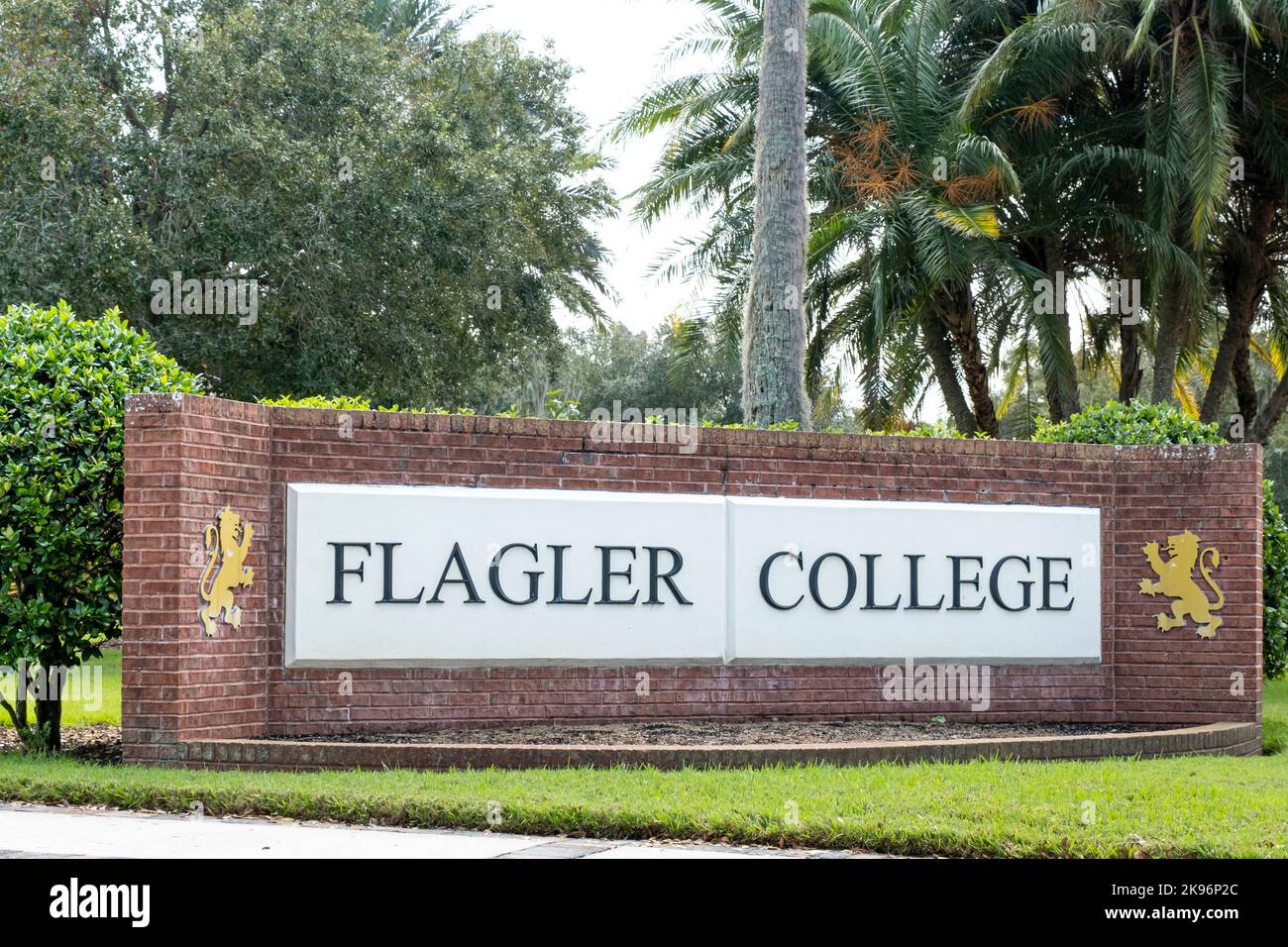 Flagler College segno di mattoni rossi con due leoni in un ambiente tropicale. Foto Stock