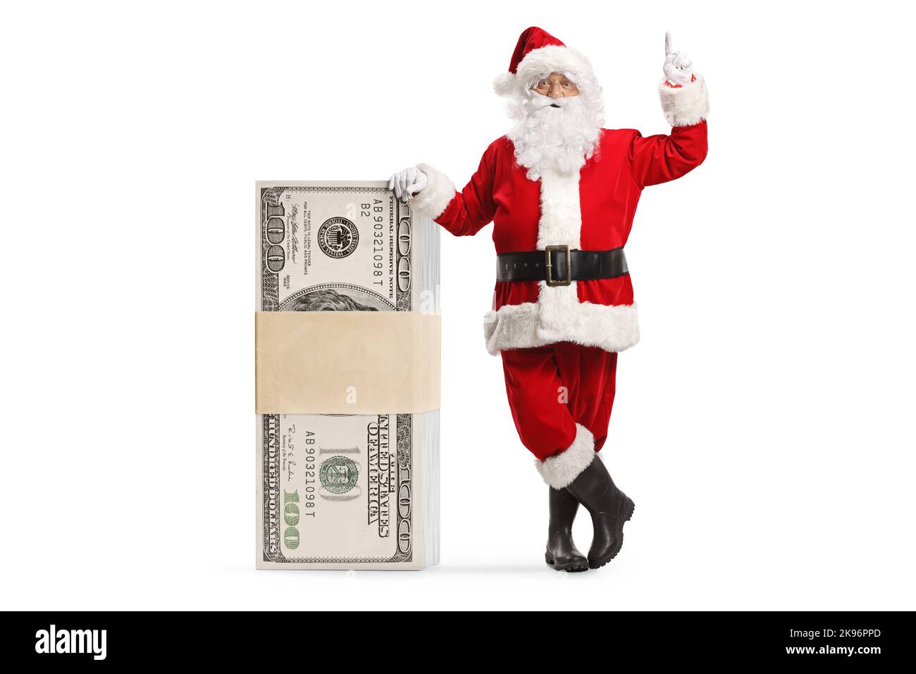 Babbo natale appoggiato su una pila di soldi e puntando isolato su sfondo bianco Foto Stock