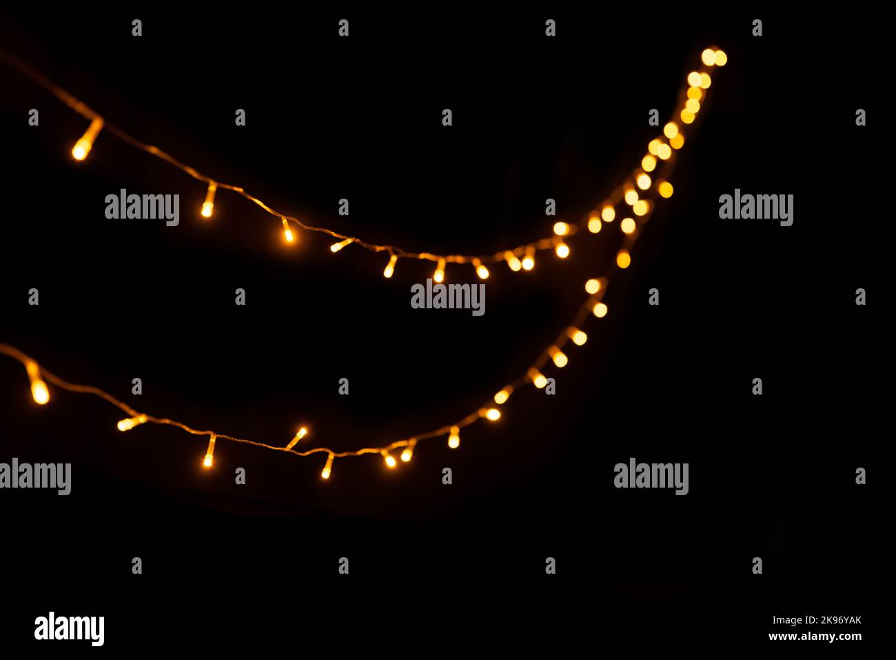 Astratto luci di Natale su sfondo nero. Lampada a incandescenza per ghirlatura, Foto Stock