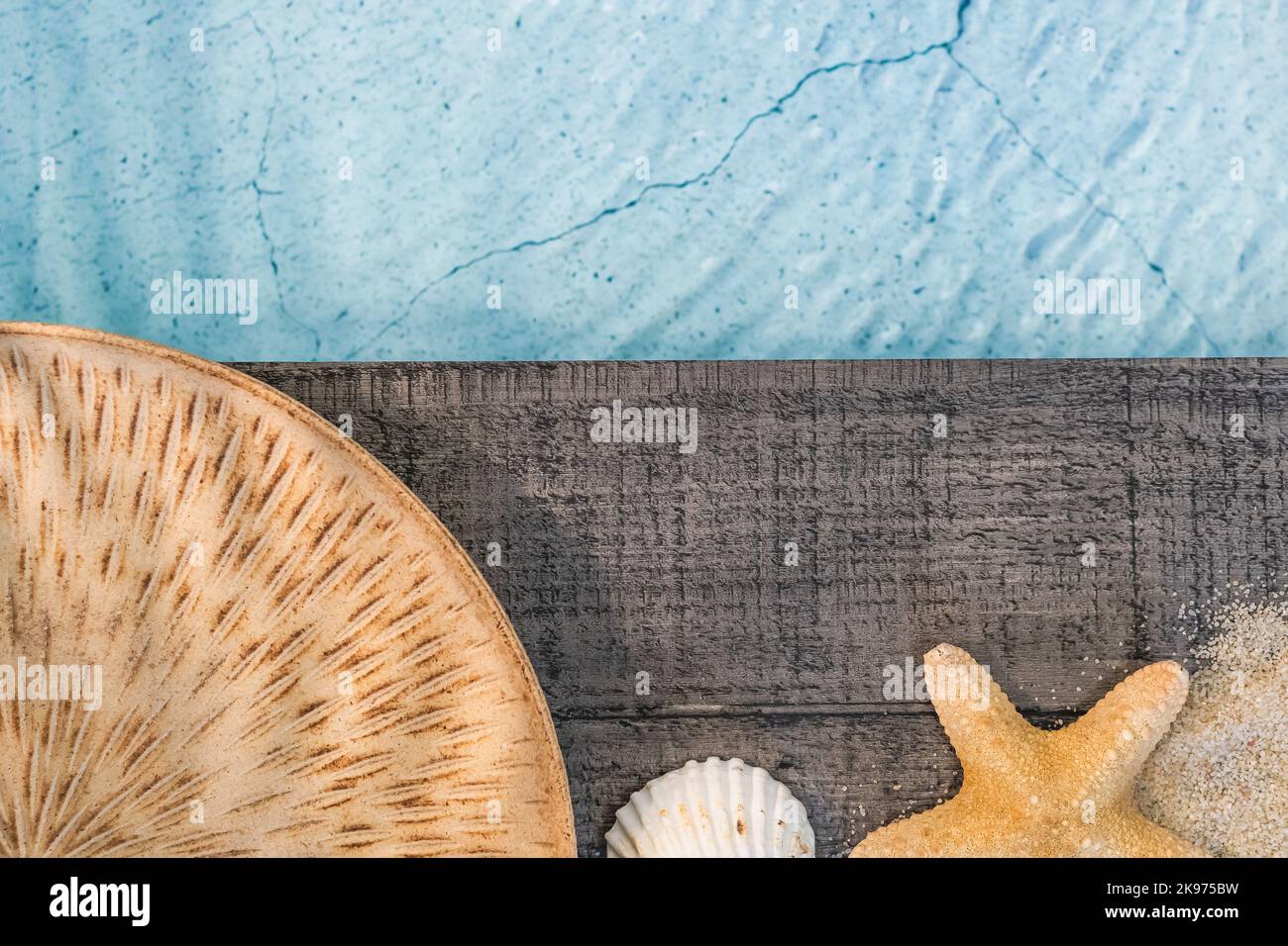 Piatto esotico visto dall'alto su un pavimento di legno sopra una piscina con conchiglie. Atmosfera vacanza in estate. Foto Stock