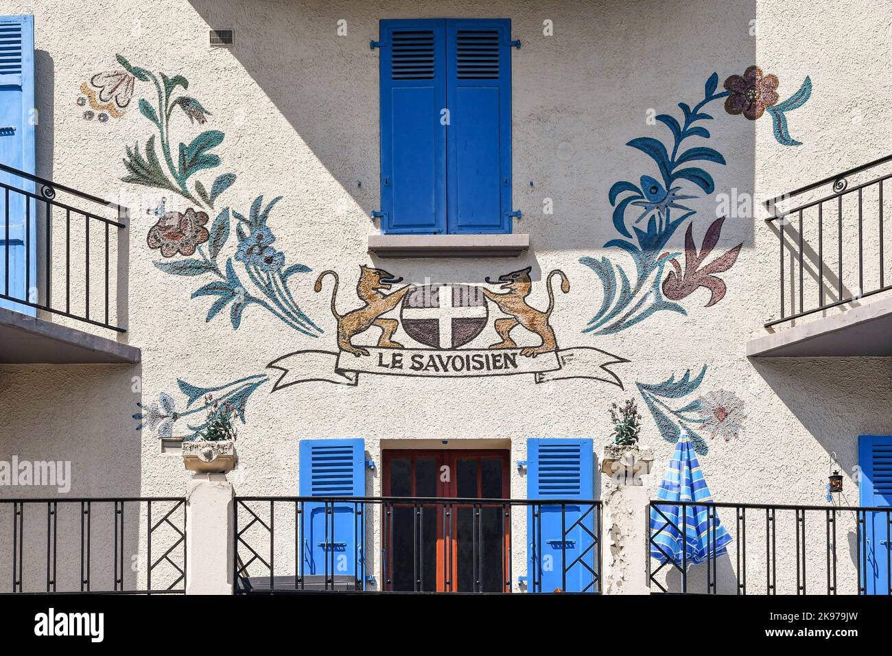 Particolare di una decorazione murale sulla facciata di un edificio nel centro della città alpina con uno stemma circondato da fiori, Chamonix, Francia Foto Stock