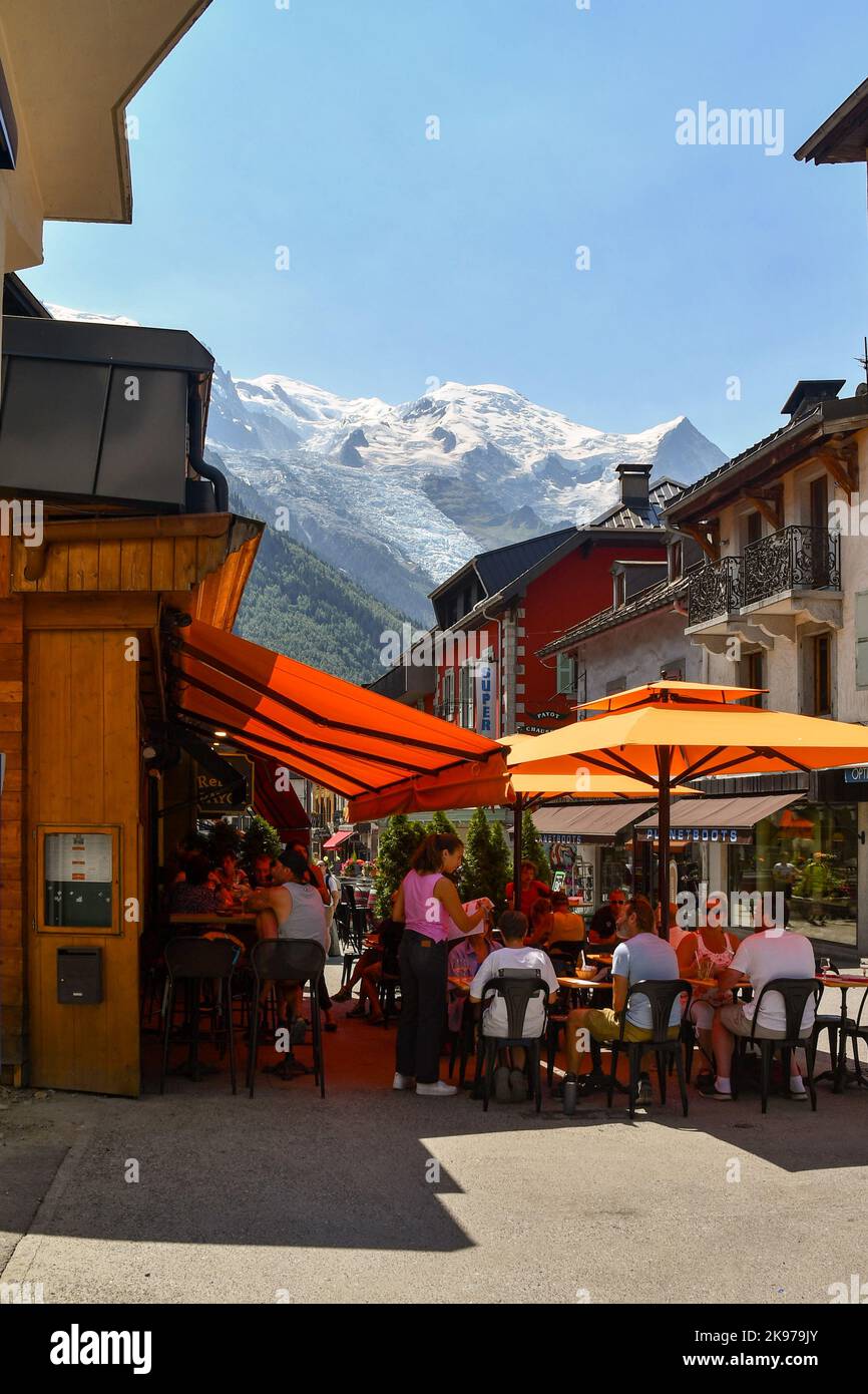 Persone sedute in un caffè marciapiede nel centro storico di Chamonix con il Monte Bianco sullo sfondo in estate, alta Savoia, Francia Foto Stock