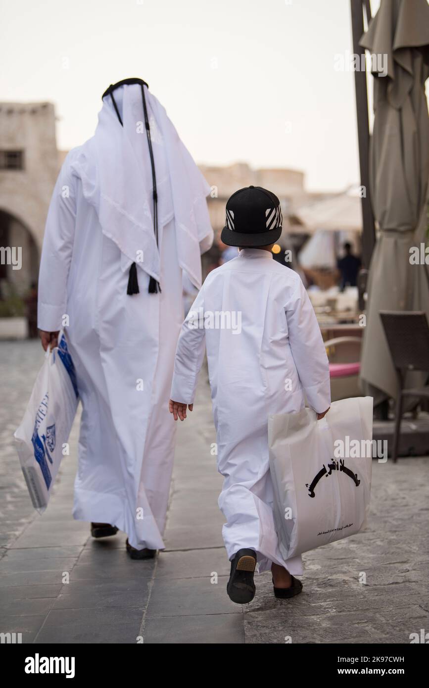 Doha, Qatar - 05 marzo 2019 : la famiglia Qatari in abbigliamento tradizionale appendere fuori nel vecchio mercato del bazar Souk Waqif. Foto Stock