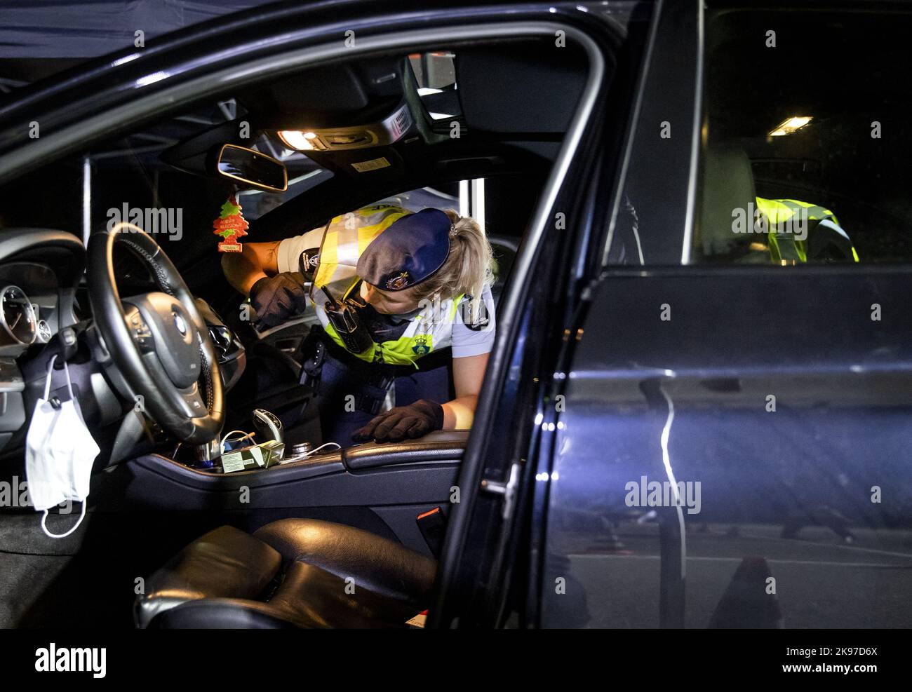 2022-10-26 19:36:17:19 MAASTRICHT - Una polizia militare cerca un'automobile durante un controllo importante. Il Royal Netherlands Marechaussee controlla le strade B intorno a Maastricht per il contrabbando di persone, assistite dalla polizia e dai colleghi belgi. I controlli sono effettuati da motociclisti e ufficiali di abbigliamento normale, tra gli altri. Allo stesso tempo, la polizia effettua controlli relativi, tra l'altro, al Road Traffic Act, al divieto di possesso di armi e alcol e al consumo di droghe. ANP SEM VAN DER WAL olanda fuori - belgio fuori Foto Stock