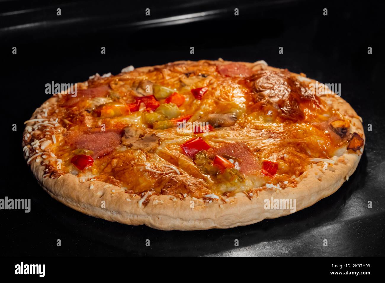 Pizza bruciata fatta in casa su vassoio in forno elettrico, sfondo nero  Foto stock - Alamy