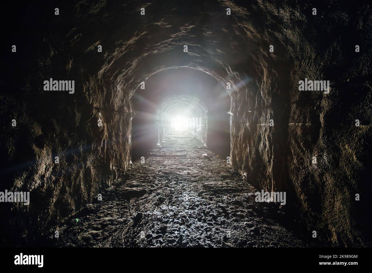Tunnel sotterraneo scuro. Luce alla fine del tunnel. Foto Stock