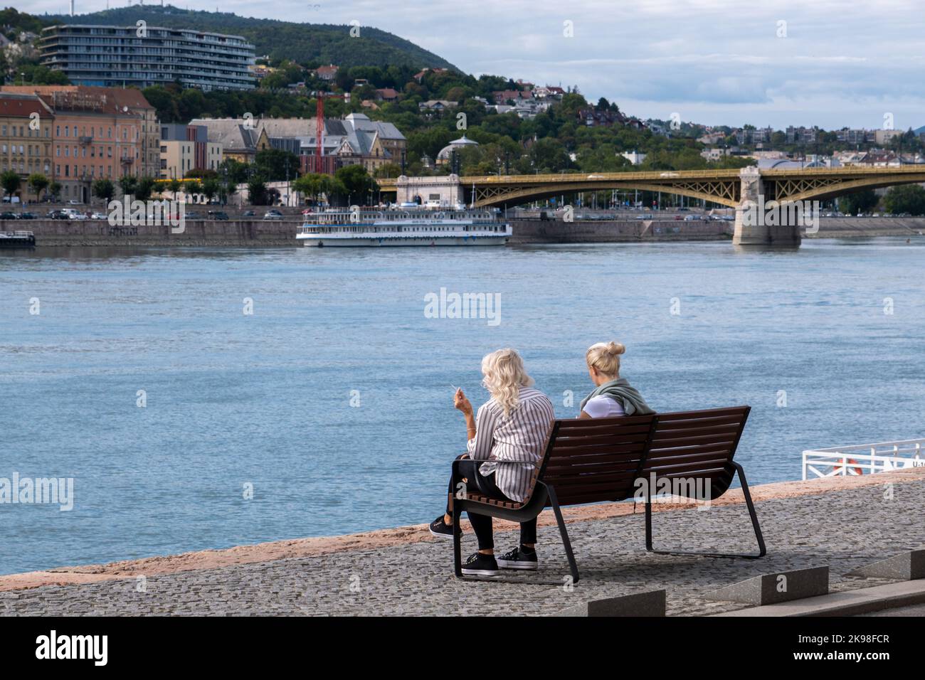 Budapest, Ungheria - 1st settembre 2022: Donne sedute su una panchina sulle rive del Danubio Foto Stock