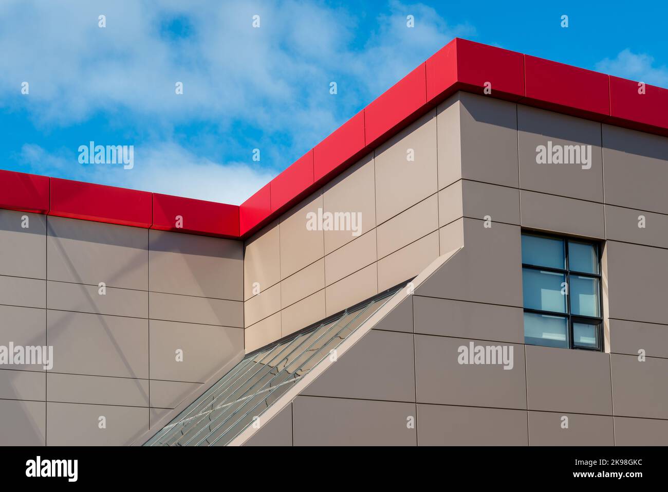 Le pareti esterne di un edificio di stile commerciale contemporaneo con pannelli compositi in metallo alluminio e finestre di vetro. L'edificio futuristico ha engi Foto Stock