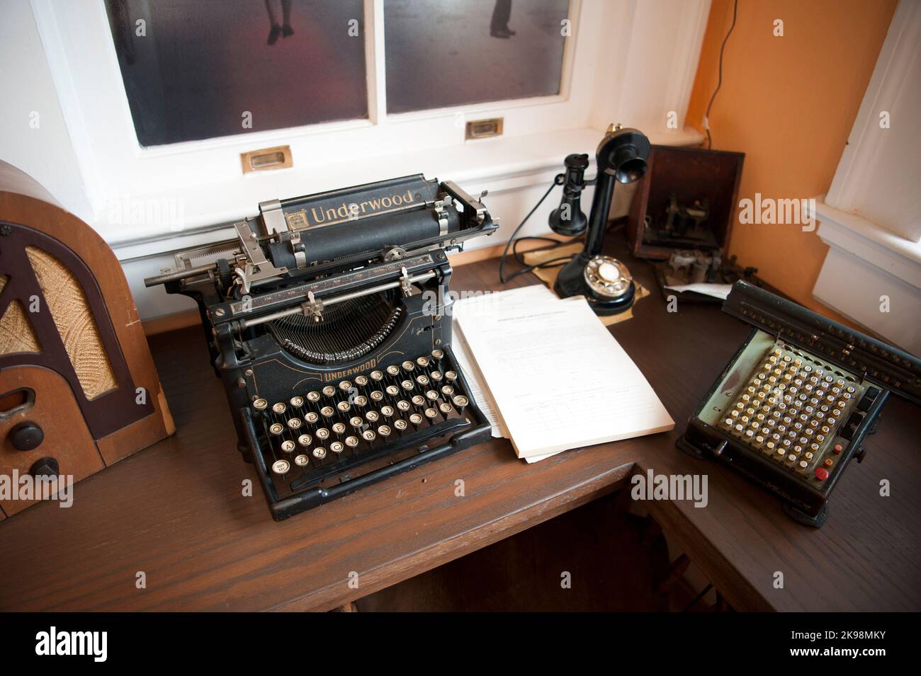 Un'antica scrivania con macchina da scrivere Underwood, telefono, radio e macchina aggiunta in un'esposizione al Dunedin Historic Museum di Dunedin, Florida, USA Foto Stock