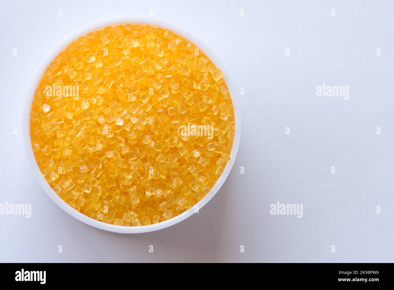 Cristalli di zucchero giallo versati da un vaso Foto Stock