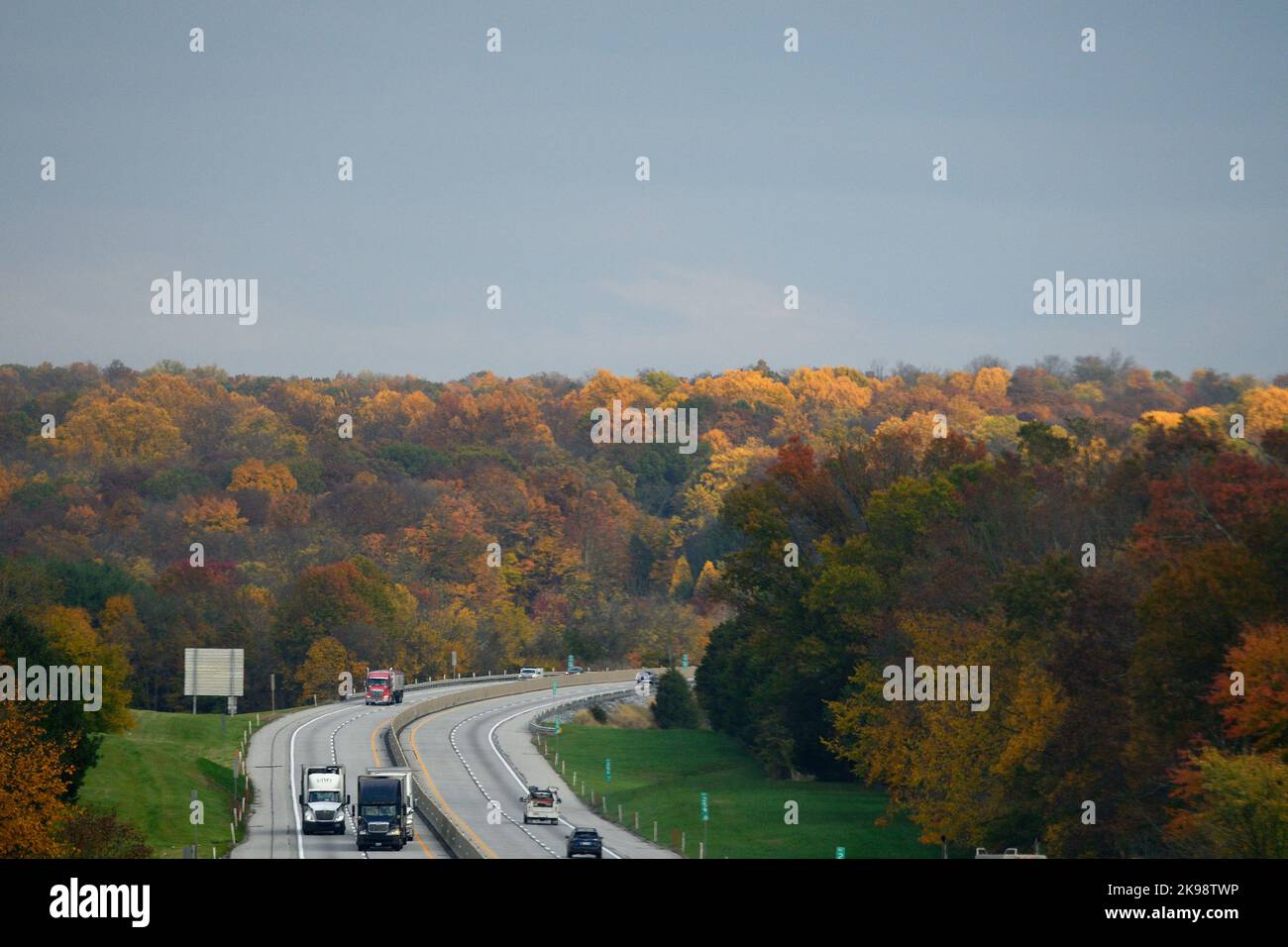 Il traffico corre oltre il fogliame dell'albero nei colori di caduta di picco che fiancheggiano la Pennsylvania turnpike Interstate i-76, tra Harrisburg e Philadelphia, Pennsylvania, Stati Uniti il 26 ottobre 2022. In due settimane gli americani si dirigono ai seggi elettorali per le elezioni di metà mandato, che potrebbero avere enormi implicazioni sulla forma della Nazione. Credit: OOGImages/Alamy Live News Foto Stock