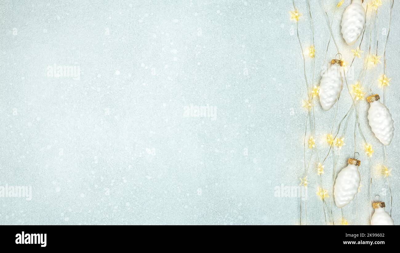 ornamenti bianchi di natale e luci incandescenti ghirland su sfondo festivo argento. piatto, vista dall'alto. Foto Stock