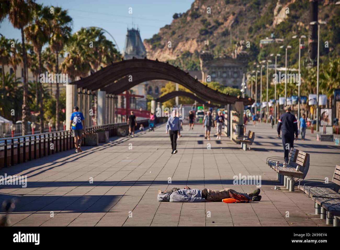 Catalonia capitale Barcellona in Spagna. Senzatetto che dorme lungo la passeggiata al porto turistico Foto Stock