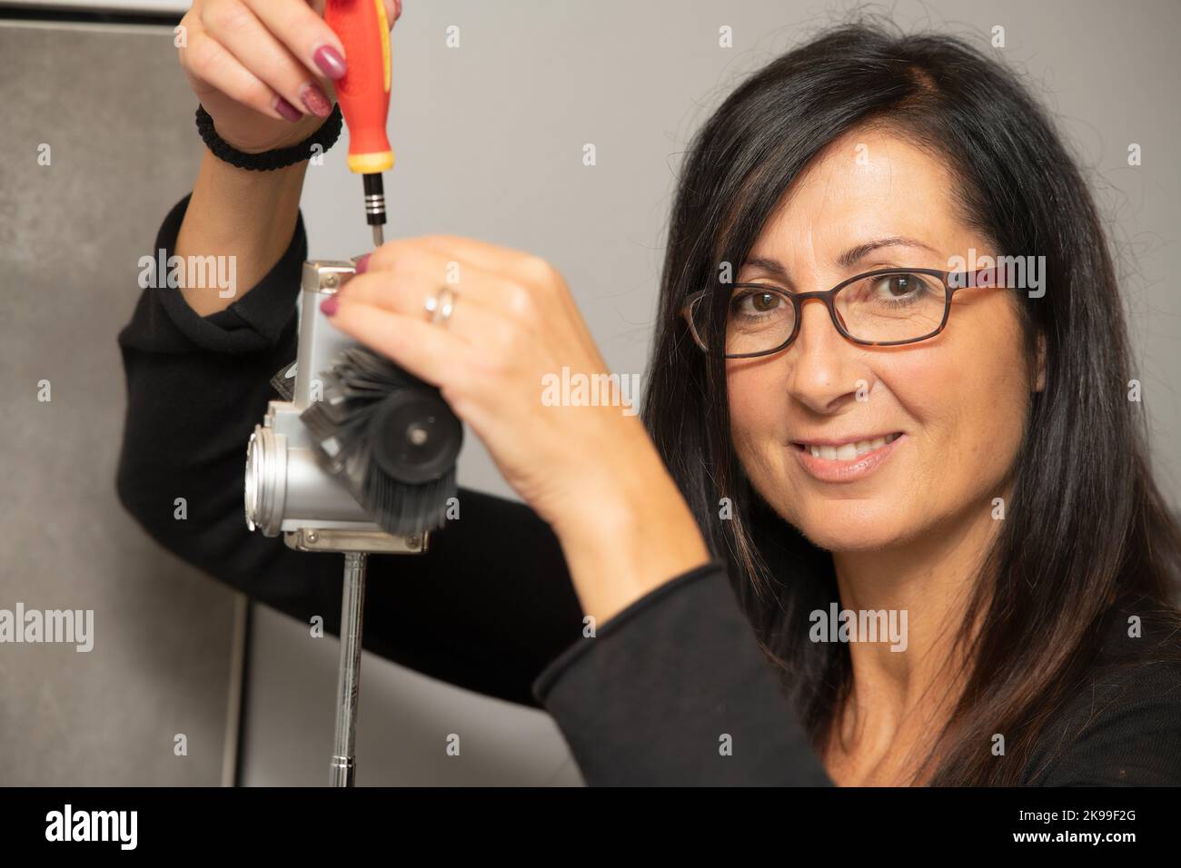 L'orologiaio sta riparando l'orologio meccanico analogico da tavolo nella sua officina. Foto Stock