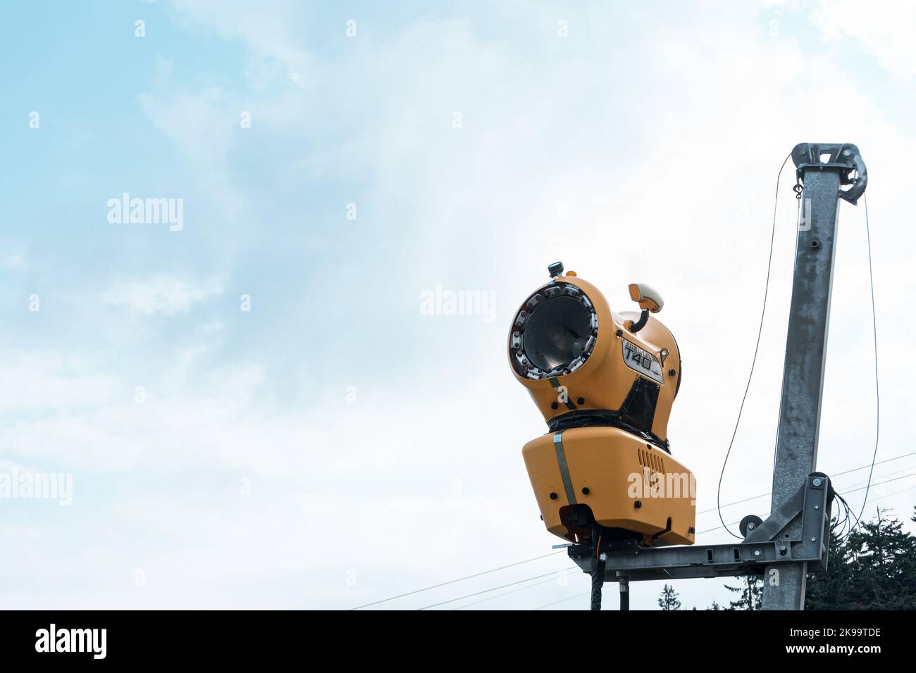Un cannone da neve sul bordo di un canyon sotto il cielo blu Foto Stock