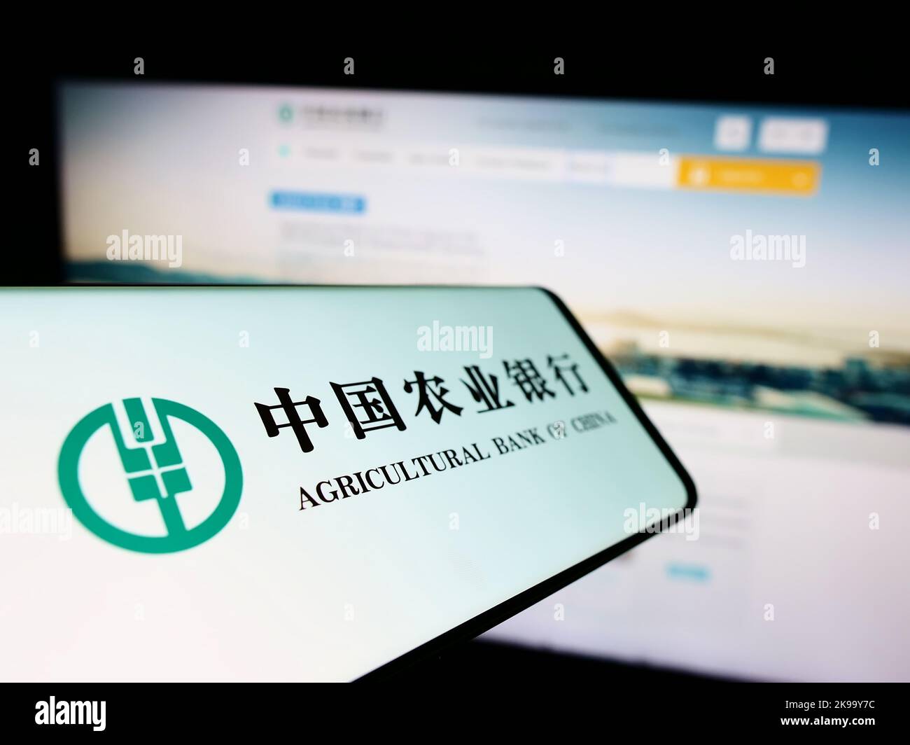 Telefono cellulare con il logo della società cinese Agricultural Bank of China sullo schermo di fronte al sito web. Messa a fuoco al centro a sinistra del display del telefono. Foto Stock