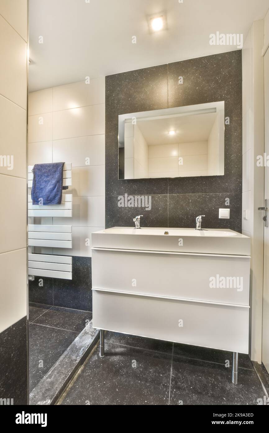 Moderno lavabo in bagno aperto con parete e finestra piastrellate grigie Foto Stock